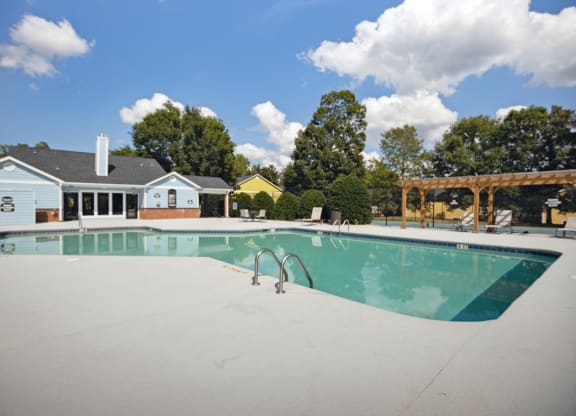 a swimming pool with a house in the background