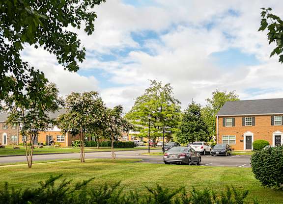 A view of a street with cars and houses.