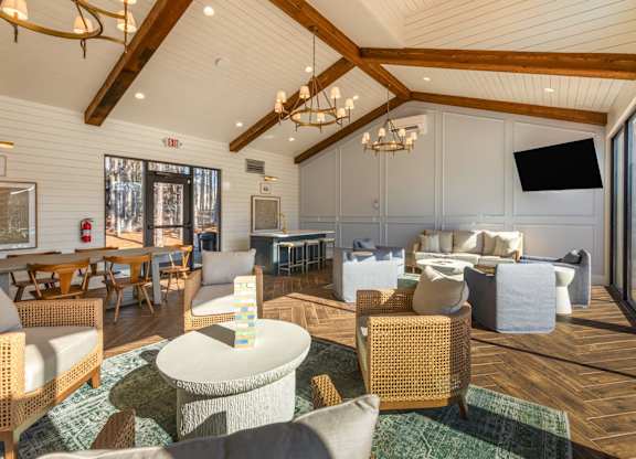 A large, well-lit room with wooden floors and furniture.
