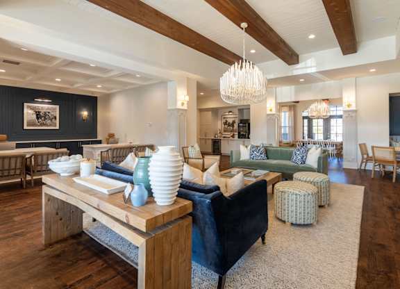A modern living room with a wooden floor and a large chandelier.
