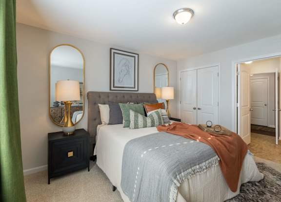 A bedroom with a bed, nightstand, and two lamps.