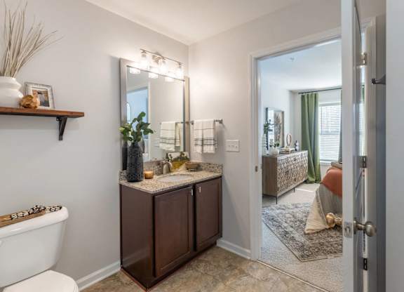 A bathroom with a white tub and a brown vanity.