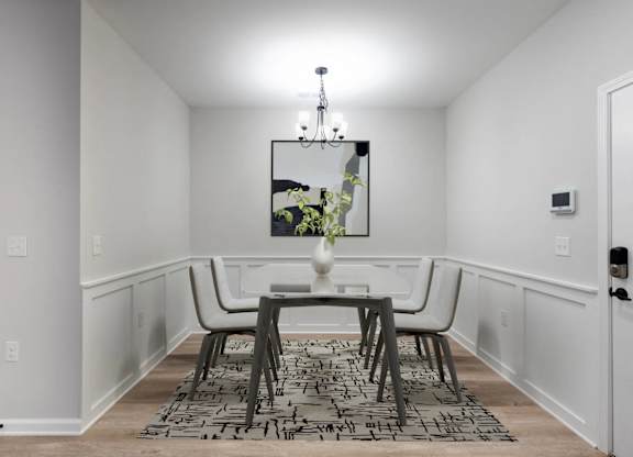 A dining room with a table and chairs.