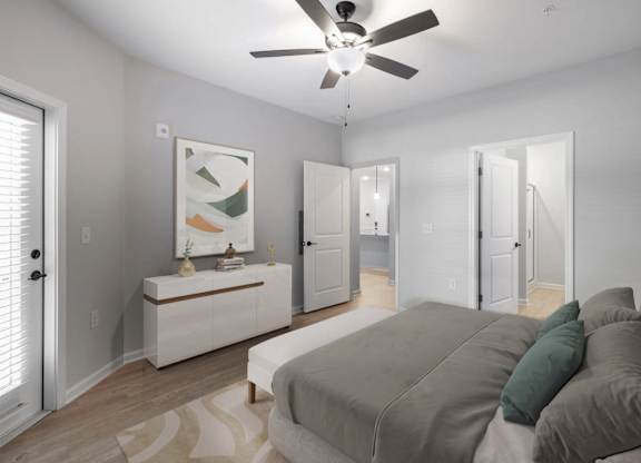 A bedroom with a bed, a dresser, and a ceiling fan.