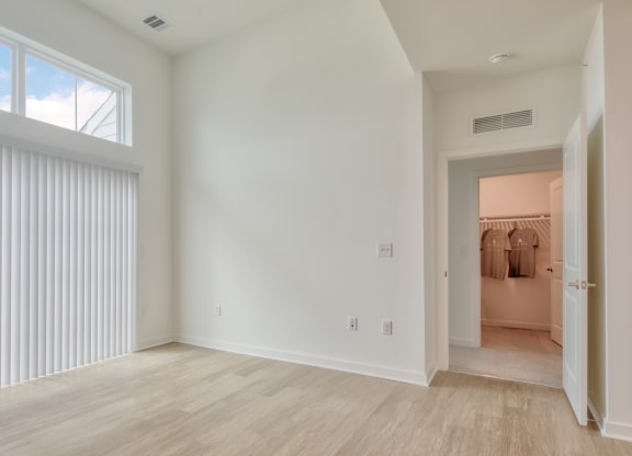 an empty living room with white walls and a large window at Allure at Edinburgh, Virginia