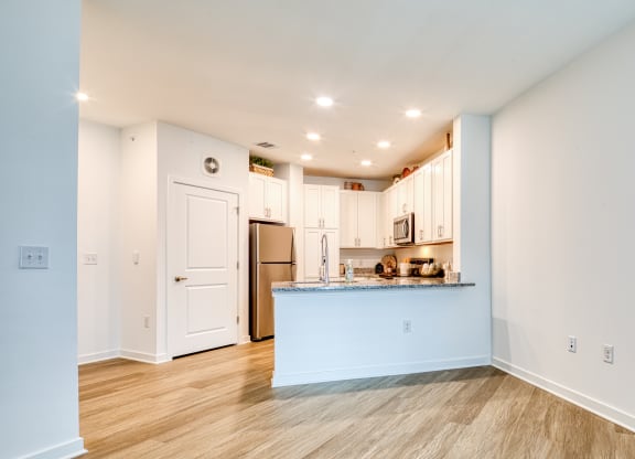 a living room with a kitchen and a blue counter top at Allure at Edinburgh, Virginia
