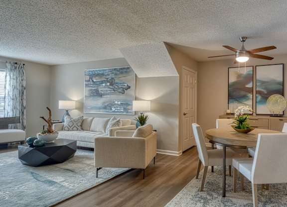 A living room with a couch, chairs, and a table.
