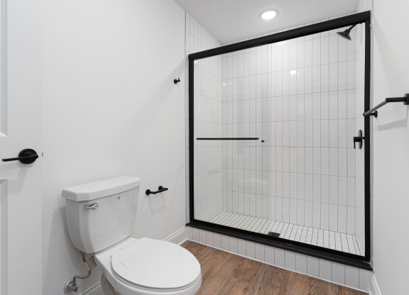 a white bathroom with a shower and a toilet at The Madison, Columbus, Ohio