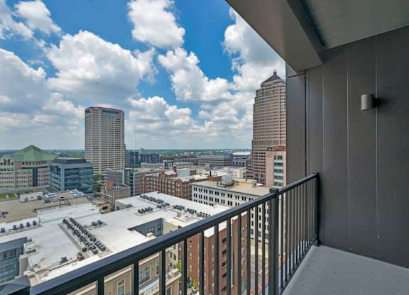 A balcony overlooks a cityscape with tall buildings.