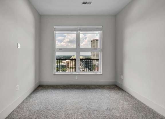 A room with a large window overlooking a cityscape.