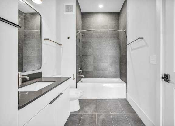 A bathroom with a white tub and toilet.
