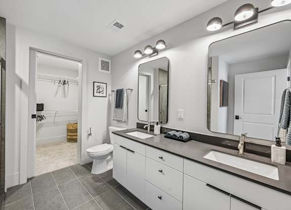 A bathroom with a white toilet, sink, and mirror.