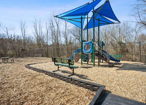 a playground with a blue structure and benches