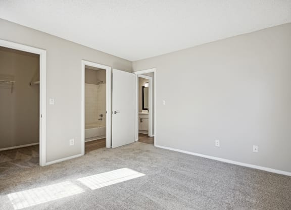 an empty living room with an open door to a bathroom