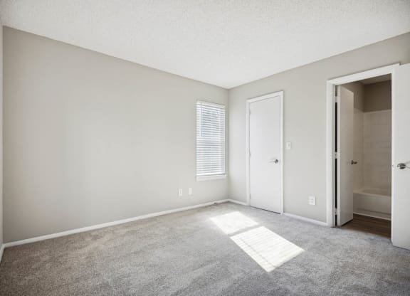 an empty living room with a door to a bathroom