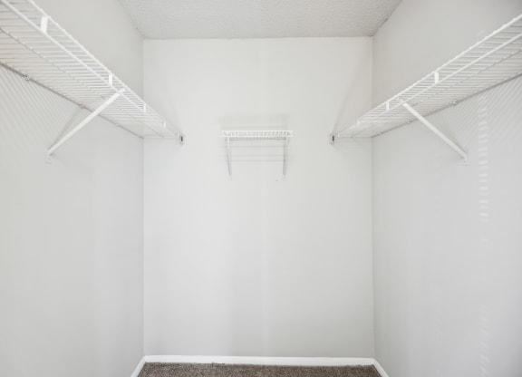 an empty room with white walls and white racks on the wall