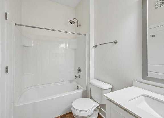 A white bathroom with a toilet, sink, and bathtub.