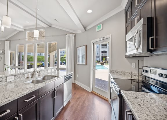 a large kitchen with granite counter tops and stainless steel appliances