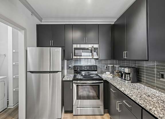 A modern kitchen with a stainless steel refrigerator and oven.