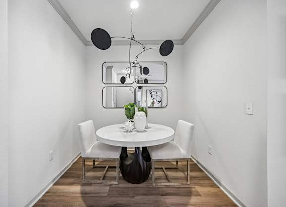 A modern dining room with a white table and chairs.