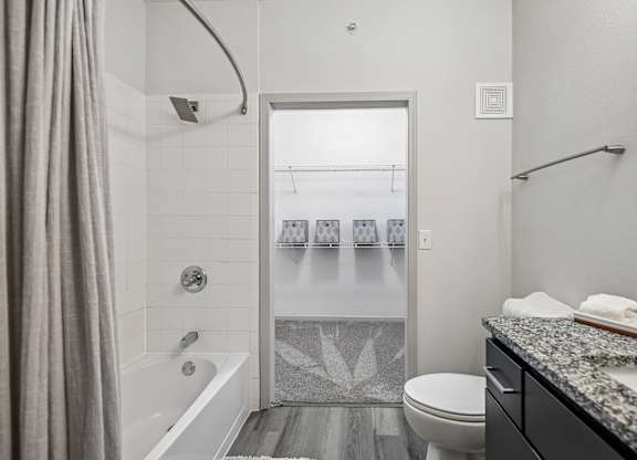 A bathroom with a white tub, toilet, and sink.