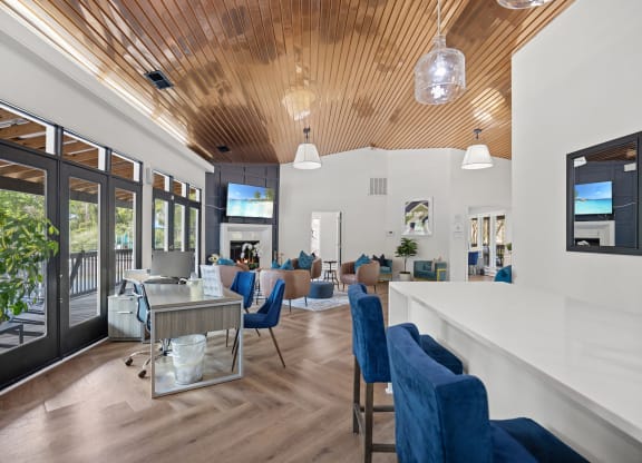 a living room with blue chairs and a bar and a fireplace