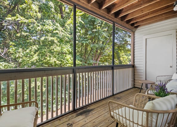 a porch with a couch and chairs and a sliding glass door