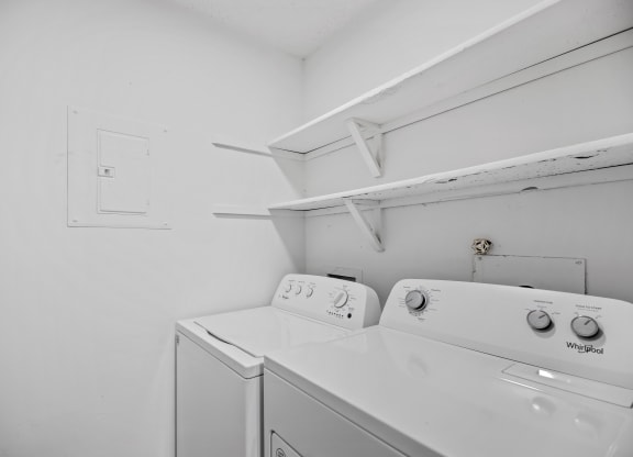 a washer and dryer in a white room with a white wall and a