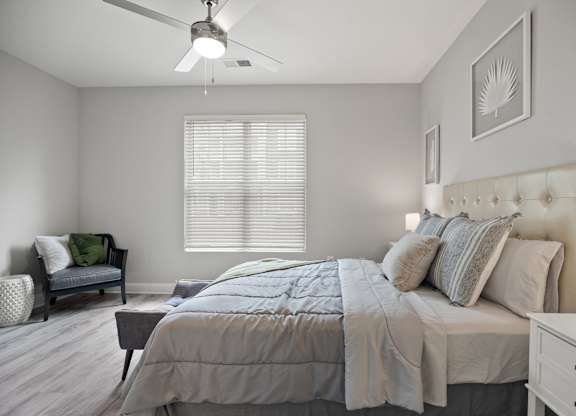 A bedroom with a bed, dresser, and chair.