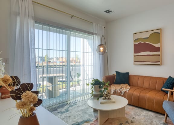 a living room with a couch and a table and a balcony