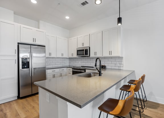 a kitchen with a large island and a stainless steel refrigeratorat Oak Grove at Blake Farm, Wilmington, North Carolina