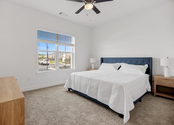 a bedroom with a large bed and a ceiling fanat Oak Grove at Blake Farm, Wilmington, 28411
