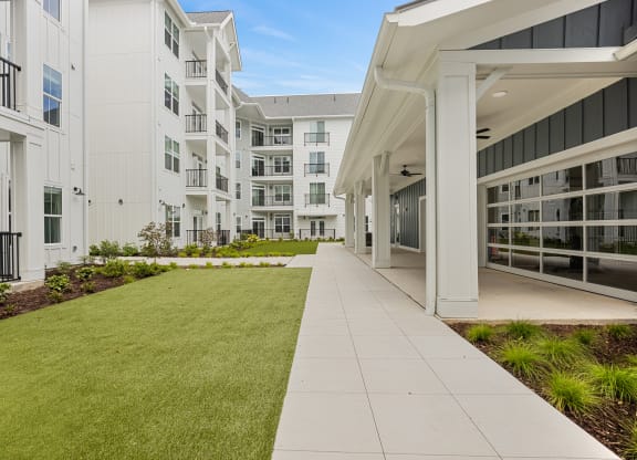 an exterior view of an apartment building with a lawn and walkwayat Oak Grove at Blake Farm, Wilmington, 28411