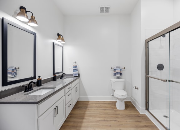 a white bathroom with a shower and a sink and a toiletat Oak Grove at Blake Farm, Wilmington, North Carolina