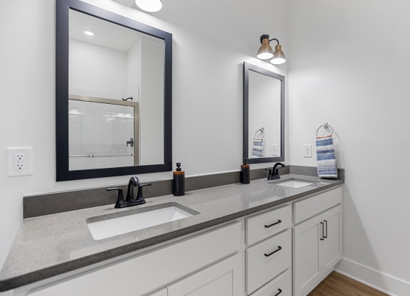 an empty bathroom with two sinks and two mirrorsat Oak Grove at Blake Farm, Wilmington, NC