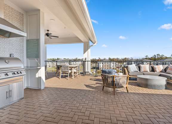 a covered patio with a grill and a table and chairs at Blake Farm, North Carolina