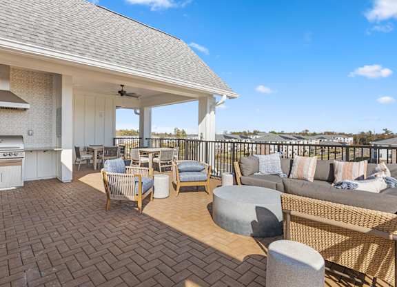 a covered patio with a grill and a table and chairs at Blake Farm, North Carolina