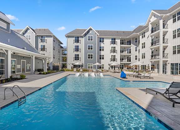 a swimming pool with an apartment building in the background at Blake Farm, North Carolina