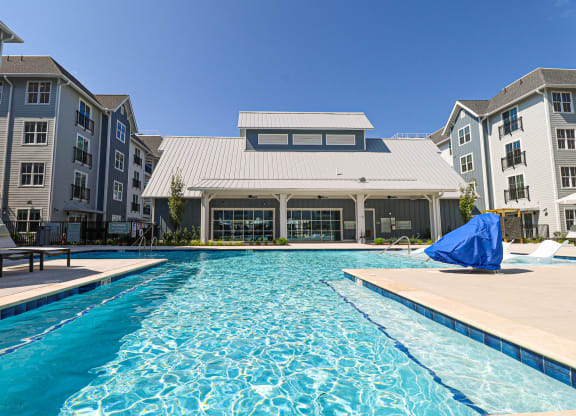 a swimming pool with an apartment building in the backgroundat Oak Grove at Blake Farm, Wilmington, North Carolina