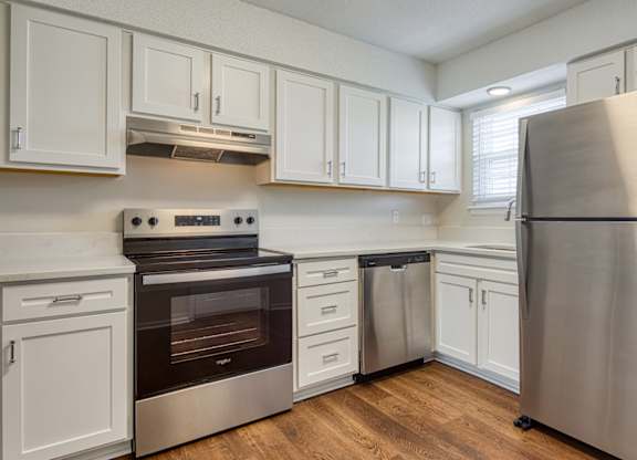 A kitchen with white cabinets and stainless steel appliances.