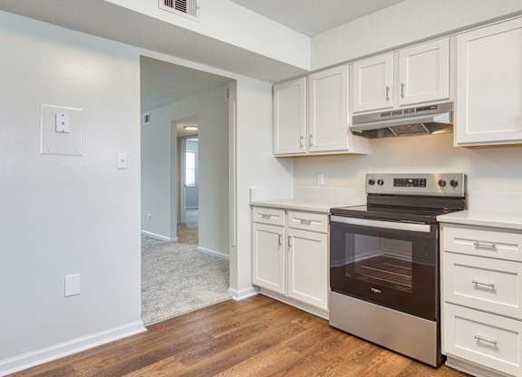 A kitchen with white cabinets and a stainless steel oven.