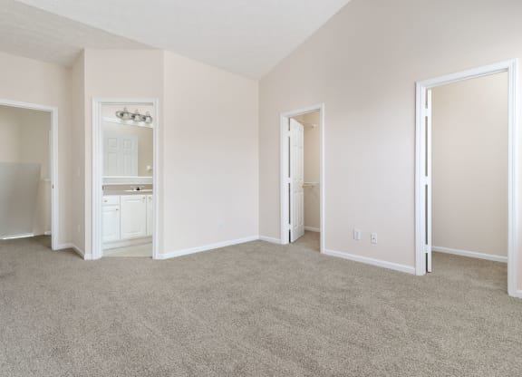 an empty living room with white walls and carpet