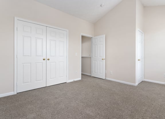 an empty bedroom with two closets and two doors at Orleans Apartments, Columbus, 43221