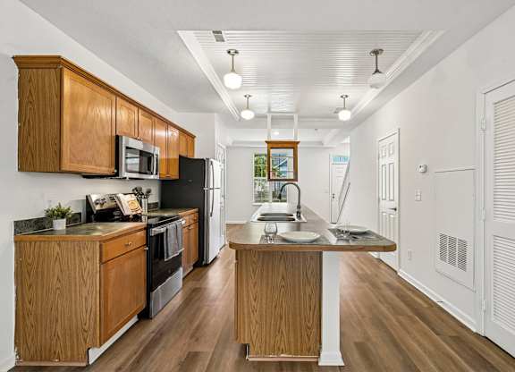 A kitchen with wooden cabinets and a black refrigerator.