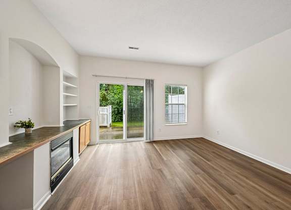 A kitchen with a wooden floor and a window.