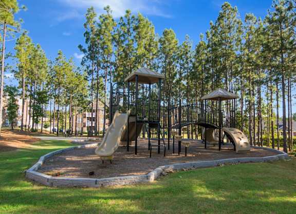 A playground with a slide, swings, and a tower.