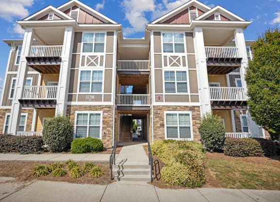 an apartment building with a sidewalk in front of it