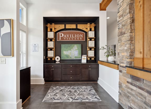 the entrance to the pavilion theater with a wood and stone wall and a television