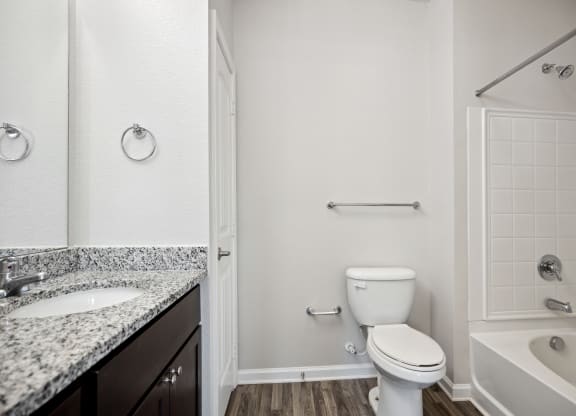 a bathroom with a toilet and a sink and a bath tub
