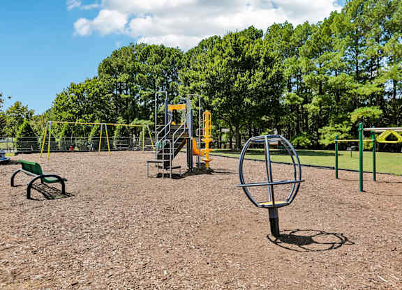 A playground with a swing set and a seesaw.